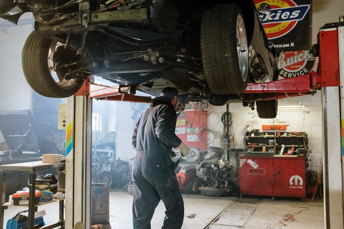 Mecánico reparando un auto suspendido